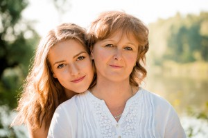 Outdoor portrait of mature mother with her teenage daughter - backlit with sun